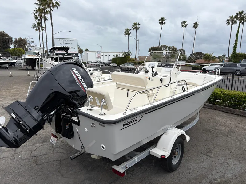 Slide: The Image of 2025 Boston Whaler 190 Montauk boat on trailer, parked outdoors with palm trees in background. - 4
