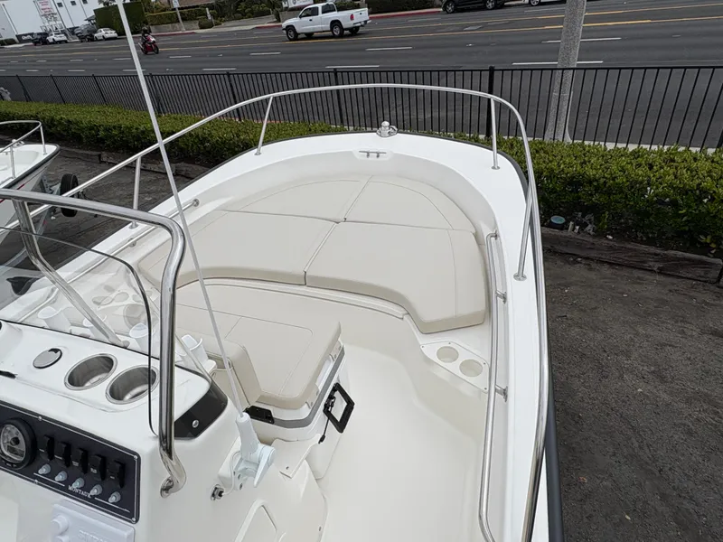 Slide: The Image of 2025 Boston Whaler 190 Montauk boat, spacious deck view, parked near a road. - 7