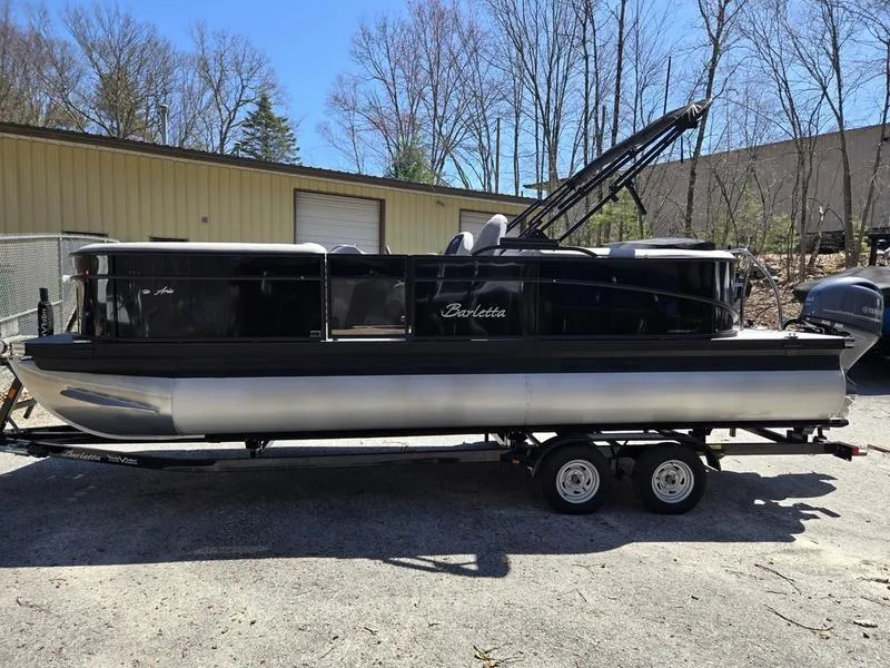 Slide: The Image of 2025 Barletta A22QC pontoon boat on trailer, parked outdoors near a building. - 5