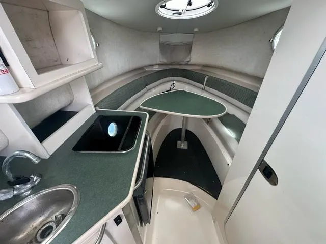 Slide: The Image of 2003 Trophy 2902 Walkaround cabin interior with kitchenette and seating area. - 10