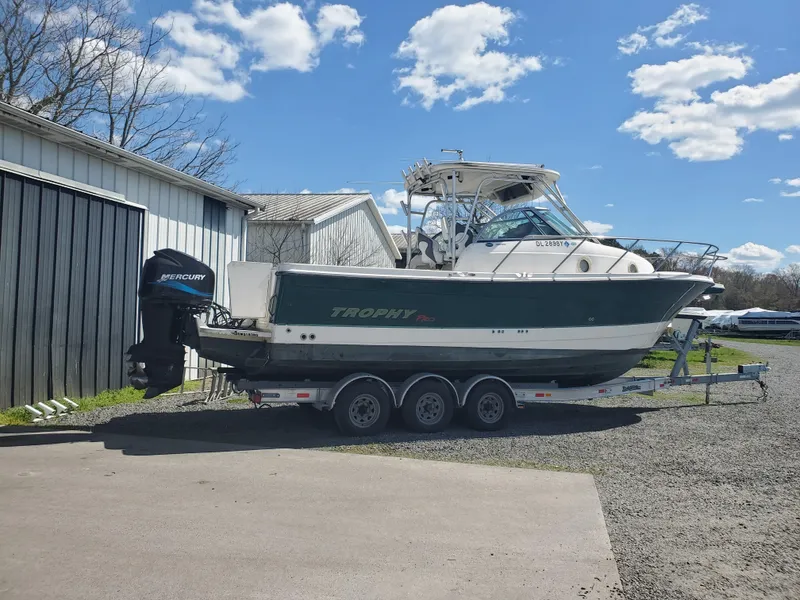 Slide: The Image of 2003 Trophy 2902 Walkaround boat on trailer, parked outdoors under blue sky. - 3