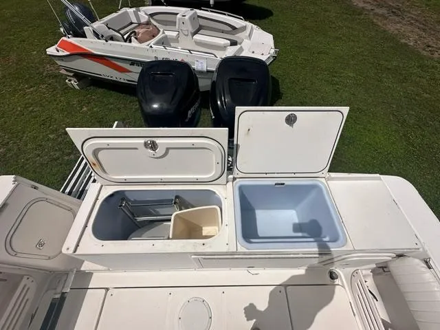 Slide: The Image of 2003 Trophy 2902 Walkaround boat with open storage compartments and dual outboard motors. - 7
