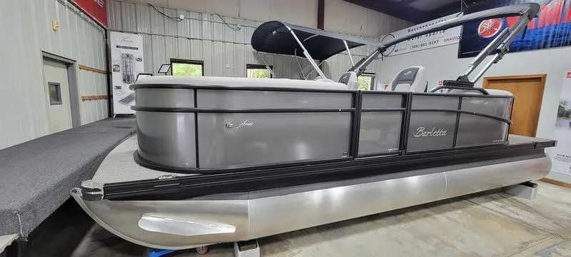 Slide: The Image of 2025 Barletta A20QC pontoon boat in showroom, side view. - 2