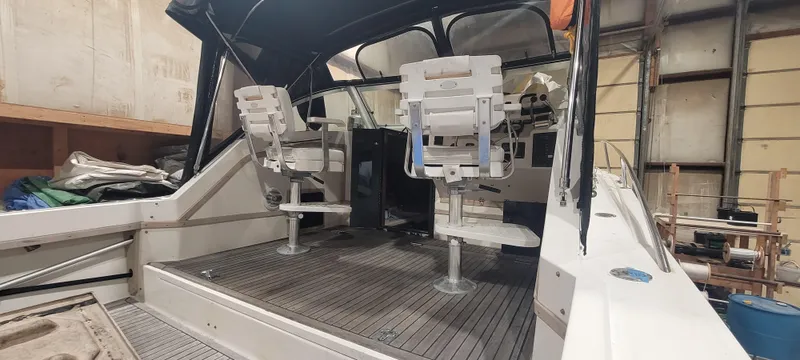 Slide: The Image of 1996 Albemarle 27 Express boat interior with seating and controls in a storage facility. - 15