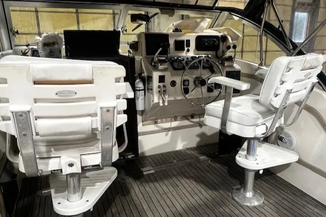 Slide: The Image of 1996 Albemarle 27 Express boat cockpit with dual white captain chairs and control panel. - 16