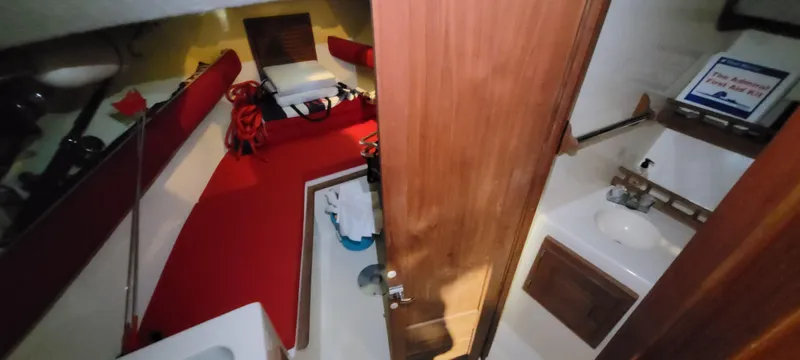 Slide: The Image of 1996 Albemarle 27 Express cabin interior with red seating and compact bathroom. - 3