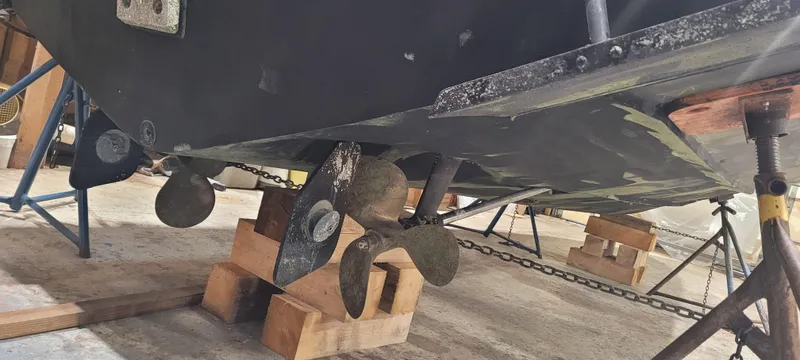 Slide: The Image of 1996 Albemarle 27 Express boat underside with propellers on wooden blocks in a workshop. - 43