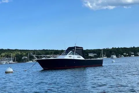 Slide: The Image of 1996 Albemarle 27 Express boat anchored on a calm lake under a clear sky. - 46