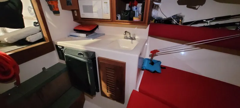 Slide: The Image of Interior of 1996 Albemarle 27 Express boat with sink and red seating. - 5