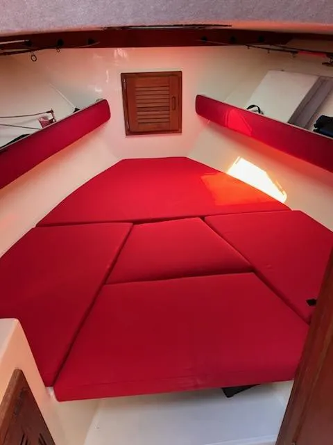 Slide: The Image of Interior cabin of a 1996 Albemarle 27 Express with red cushions and wooden accents. - 7