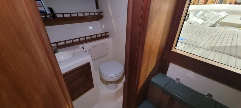 Slide: The Image of 1996 Albemarle 27 Express boat interior with compact bathroom and wooden accents. - 9