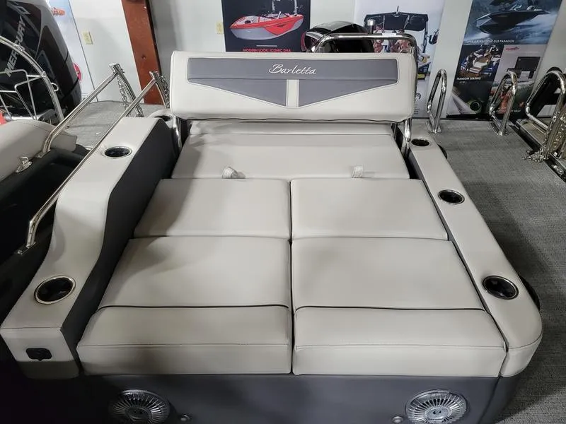 Slide: The Image of 2025 Barletta C24UE boat interior with plush seating and cup holders. - 10