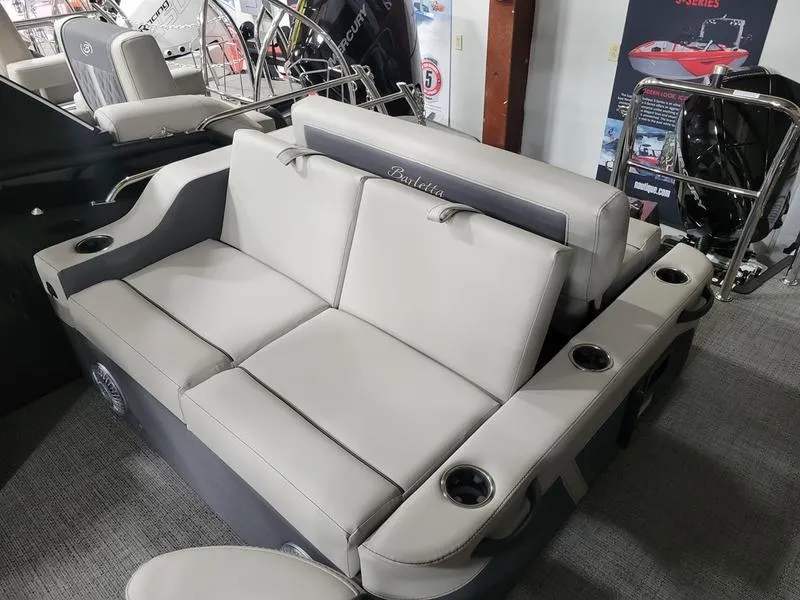 Slide: The Image of 2025 Barletta C24UE boat seating with cup holders, displayed indoors. - 12