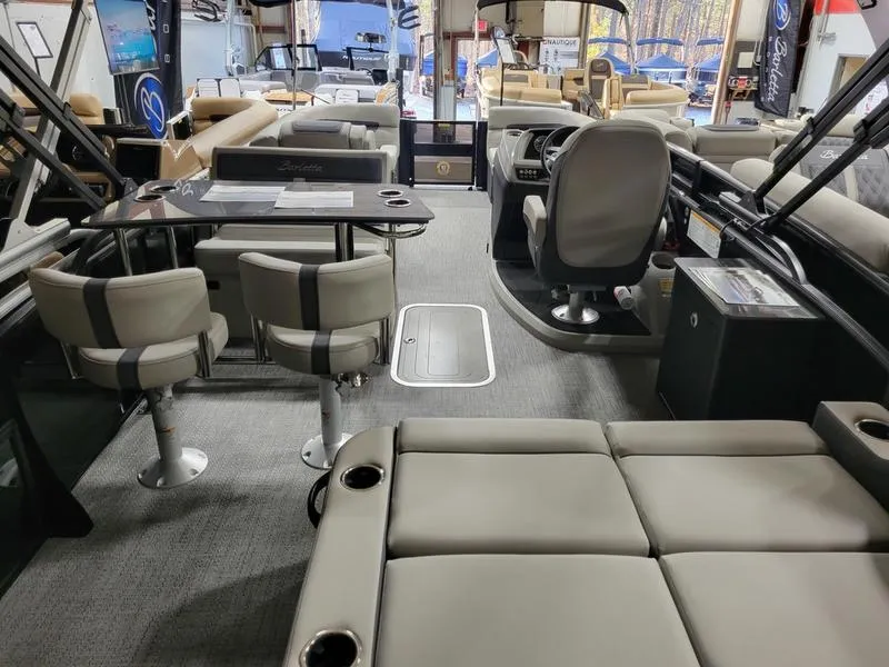 Slide: The Image of 2025 Barletta C24UE pontoon boat interior with seating, table, and helm station. - 18
