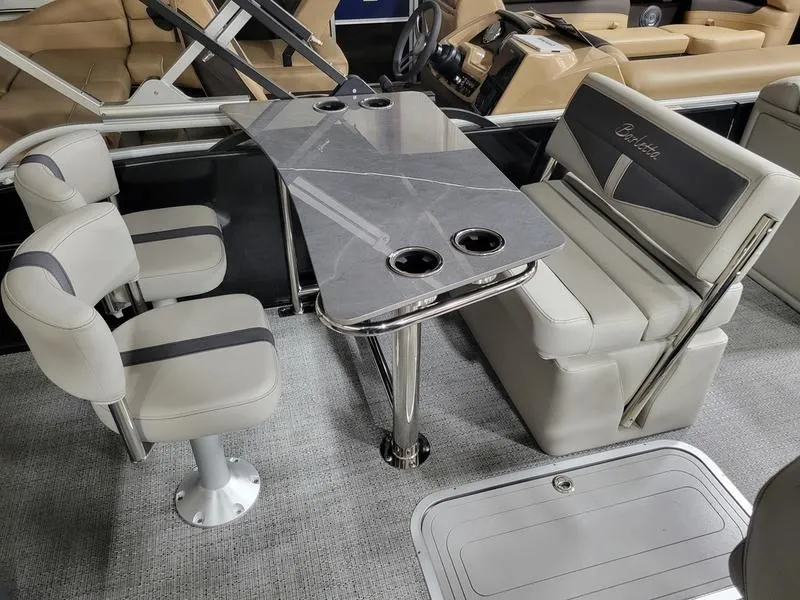 Slide: The Image of 2025 Barletta C24UE boat interior with sleek seating and modern table design. - 19