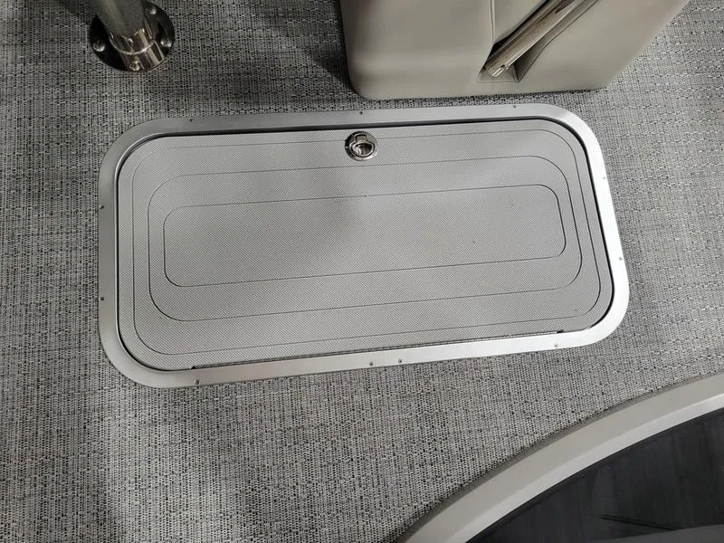 Slide: The Image of 2025 Barletta C24UE boat storage compartment with textured lid and secure latch. - 20