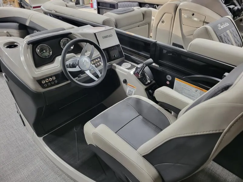 Slide: The Image of 2025 Barletta C24UE boat interior with steering console and seating. - 6