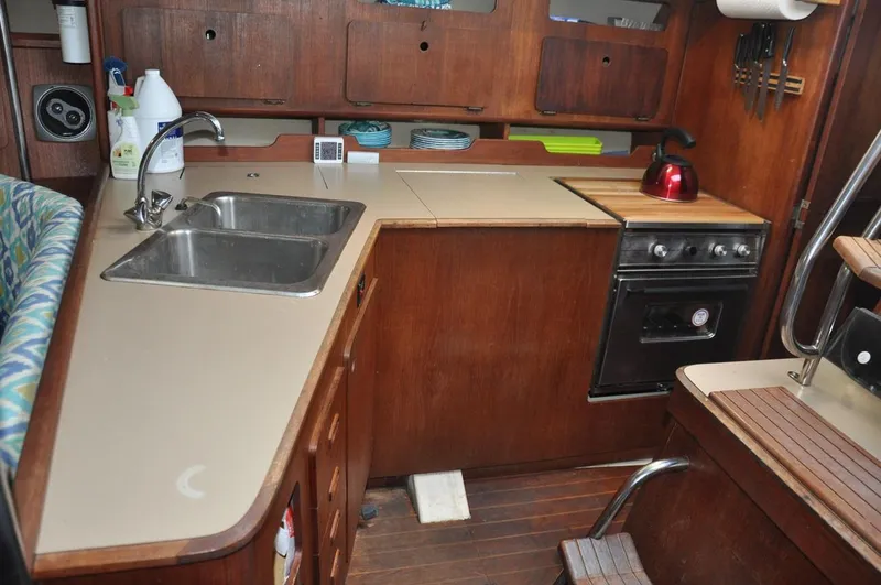 Slide: The Image of 1989 Hunter Legend 40 yacht kitchen with sink, stove, and wooden cabinetry. - 11