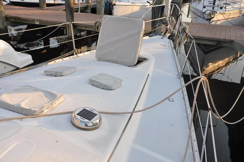 Slide: The Image of 1989 Hunter Legend 40 sailboat deck with covered hatches, docked at marina. - 3