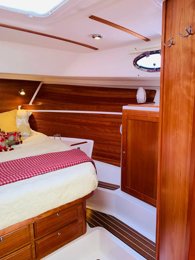 Slide: The Image of 2015 Back Cove 34 Express cabin interior with wood finish and cozy bedding. - 13