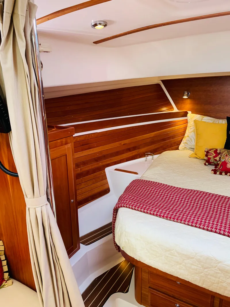 Slide: The Image of 2015 Back Cove 34 Express cabin with wood paneling and cozy bedding. - 14