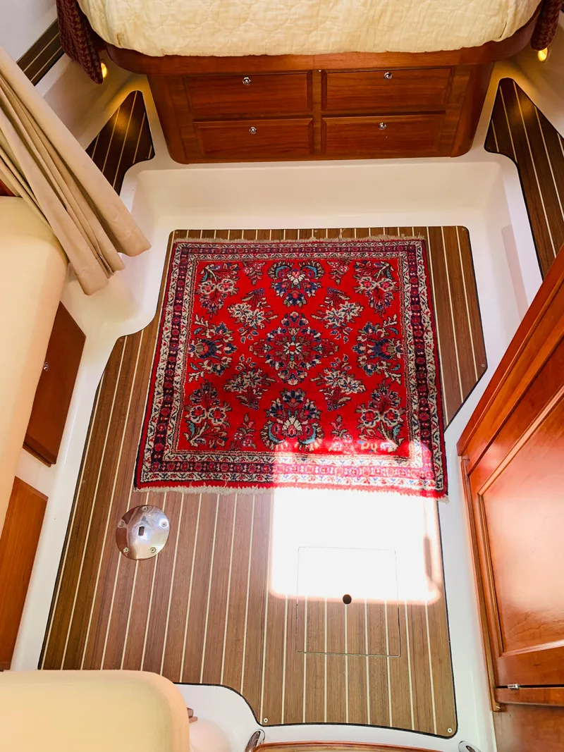 Slide: The Image of Interior of 2015 Back Cove 34 Express with wooden flooring and a red patterned rug. - 17