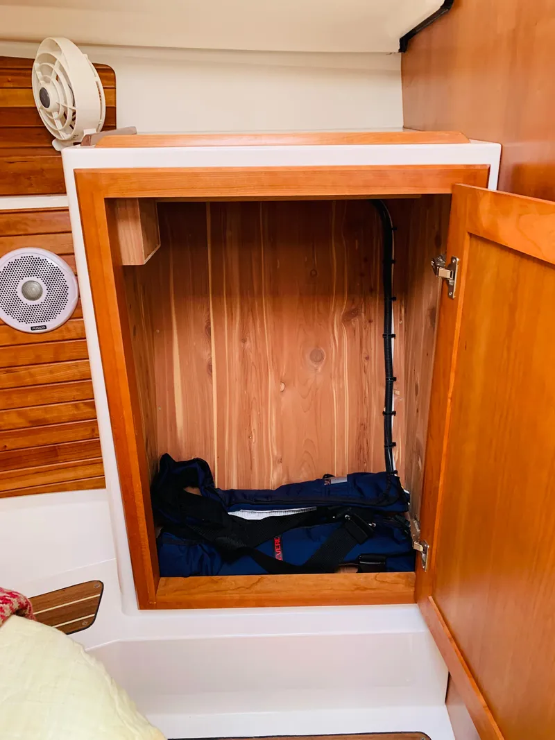 Slide: The Image of 2015 Back Cove 34 Express cabin storage with wooden interior and open door. - 19