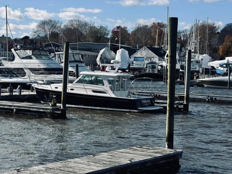 Slide: The Image of 2015 Back Cove 34 Express docked at a marina with other boats. - 2