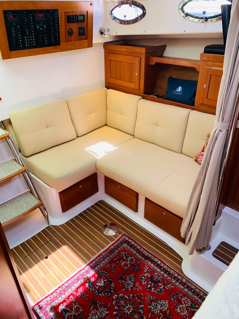 Slide: The Image of 2015 Back Cove 34 Express interior with beige seating, wooden accents, and a patterned rug. - 22