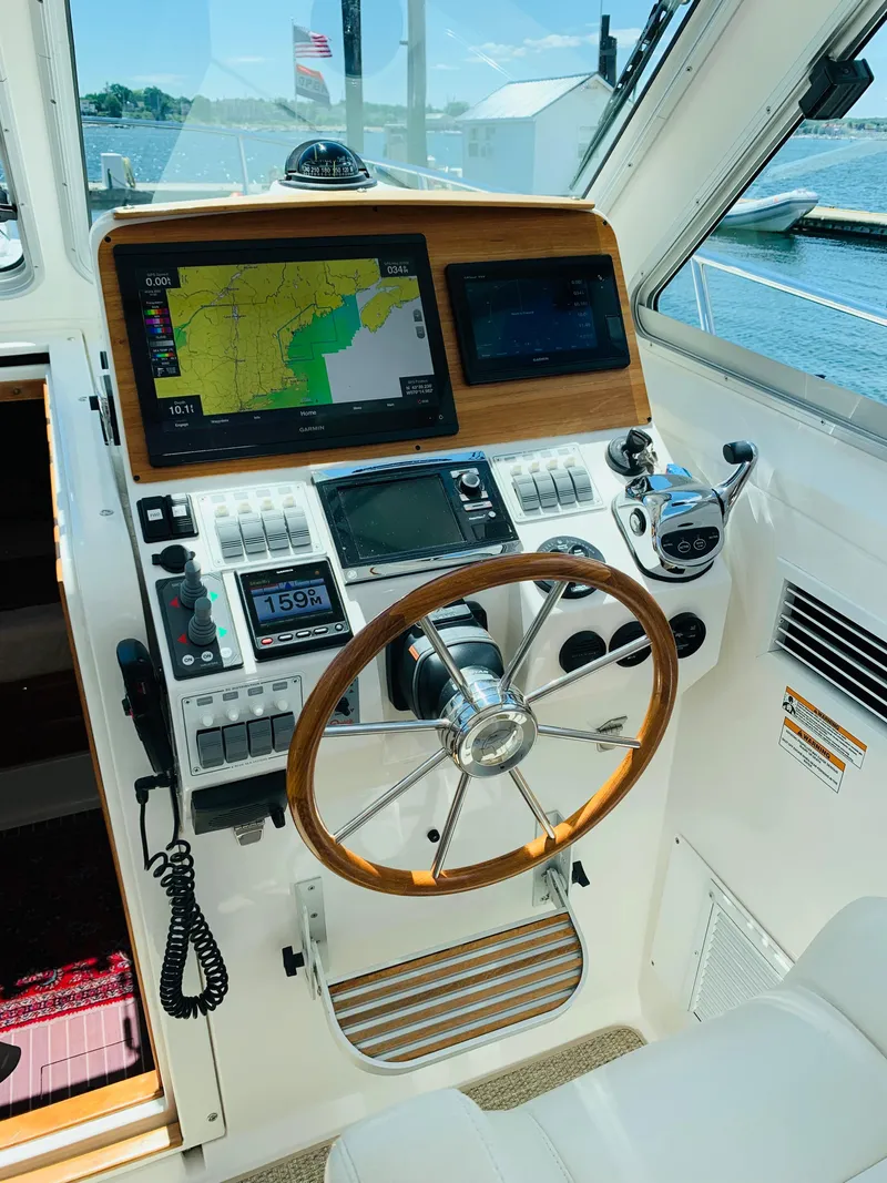 Slide: The Image of 2015 Back Cove 34 Express helm with navigation screens and wooden steering wheel. - 29