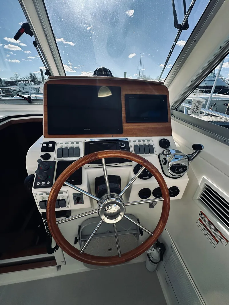 Slide: The Image of 2015 Back Cove 34 Express helm with wooden steering wheel and modern navigation controls. - 31