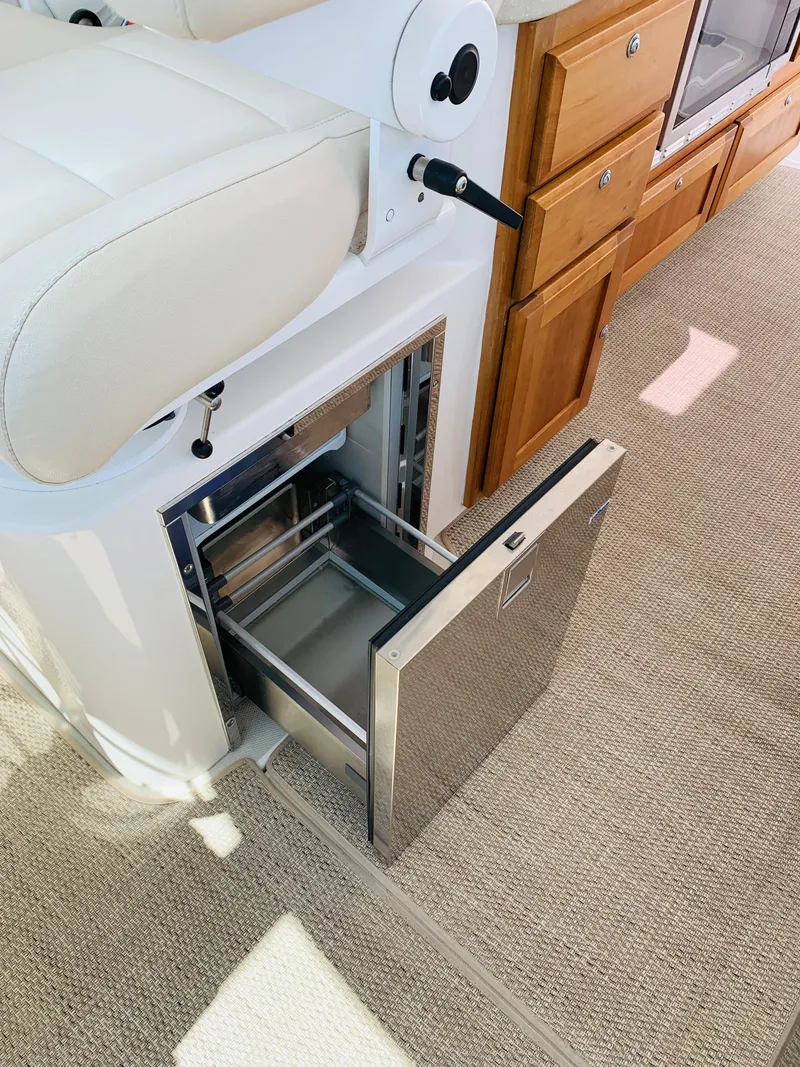 Slide: The Image of 2015 Back Cove 34 Express interior with open stainless steel drawer and beige carpet. - 36