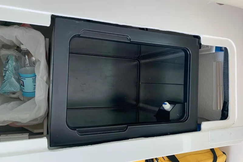 Slide: The Image of Storage compartment on a 2015 Back Cove 34 Express boat, featuring a black bin. - 38