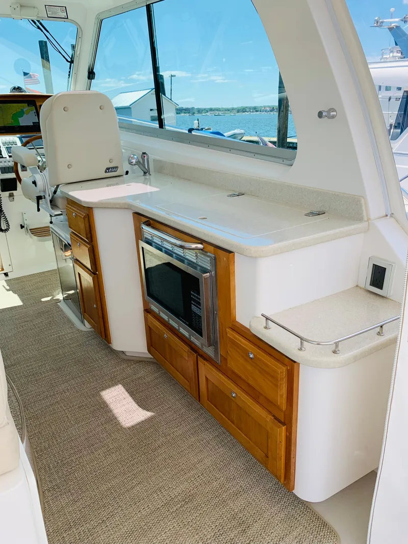 Slide: The Image of 2015 Back Cove 34 Express yacht interior with kitchenette and seating area. - 39