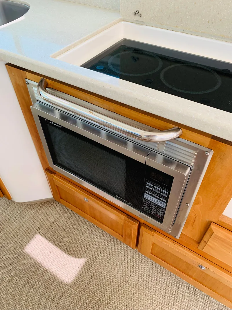 Slide: The Image of 2015 Back Cove 34 Express kitchen with microwave and stovetop. - 41