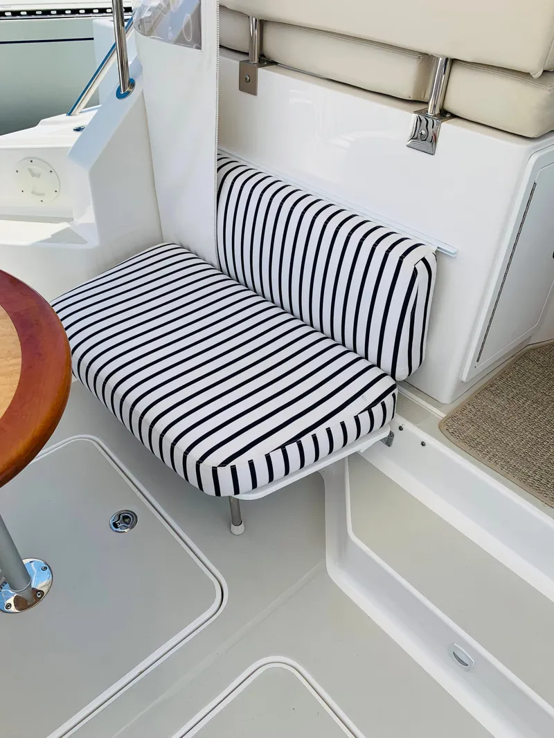 Slide: The Image of 2015 Back Cove 34 Express boat interior with striped seating and wooden table. - 47