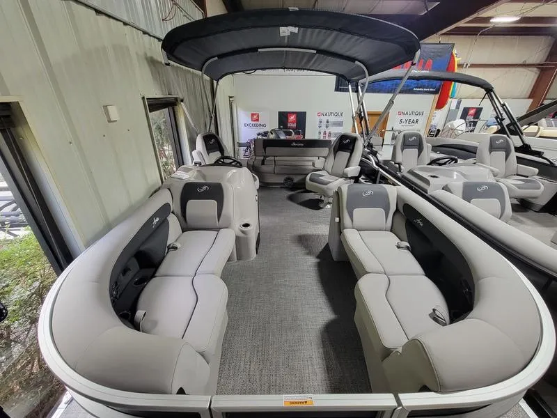 Slide: The Image of 2025 Barletta A20UC pontoon boat with spacious seating and canopy in showroom. - 3
