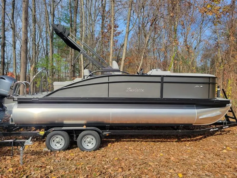 Slide: The Image of 2025 Barletta A20UC pontoon boat on trailer in wooded area. - 1