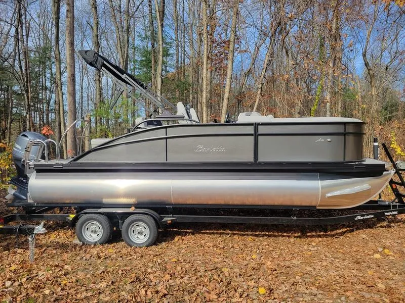 Slide: The Image of 2025 Barletta A20UC pontoon boat on trailer in wooded area. - 3