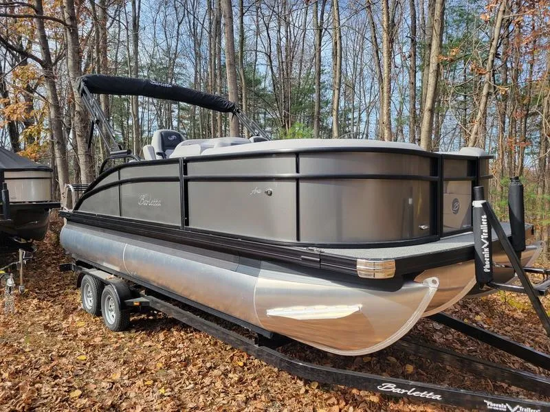 Slide: The Image of 2025 Barletta A20UC pontoon boat on trailer in wooded area. - 4