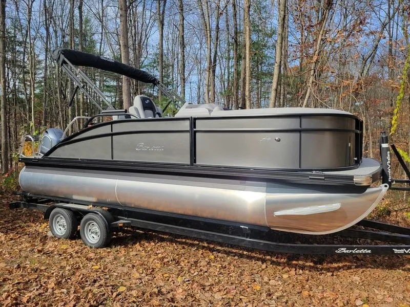 Slide: The Image of 2025 Barletta A20UC pontoon boat on trailer in wooded area. - 5