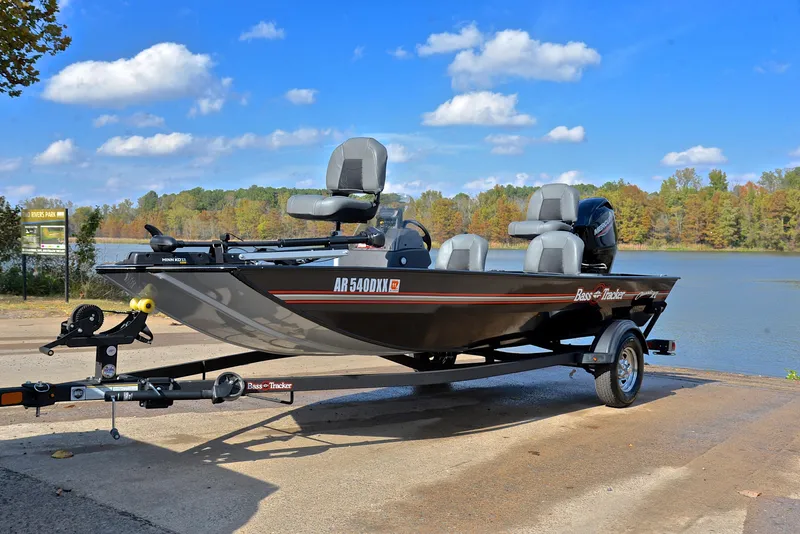 Slide: The Image of 2024 Bass Tracker Classic XL boat by a lake under a blue sky. - 10