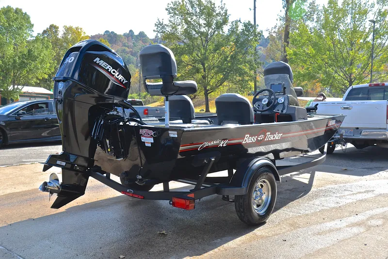 Slide: The Image of 2024 Bass Tracker Classic XL boat with Mercury engine, parked outdoors. - 14