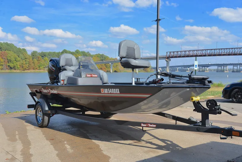 Slide: The Image of 2024 Bass Tracker Classic XL boat on trailer by a scenic lake. - 16