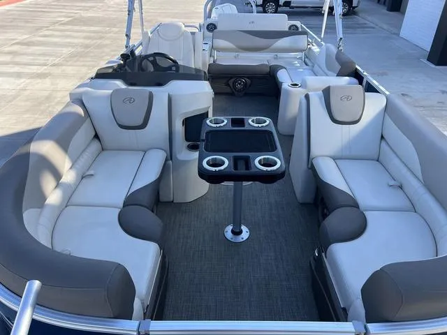 Slide: The Image of 2021 Avalon LSZ Versatile Rear Bench 24 FT pontoon boat interior with plush seating and table. - 8