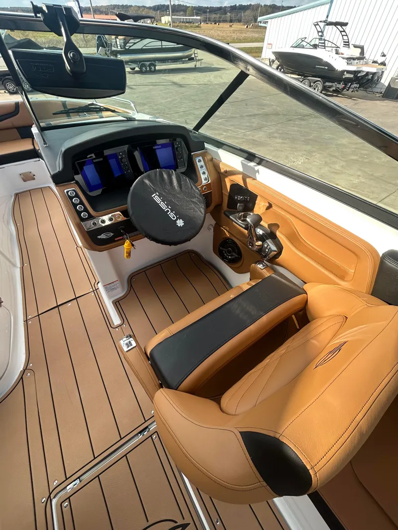 Slide: The Image of 2025 Chaparral 30 Surf boat interior with modern dashboard and tan seating. - 6