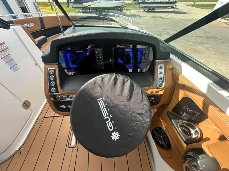 Slide: The Image of 2025 Chaparral 30 Surf boat dashboard with steering wheel cover and dual displays. - 7