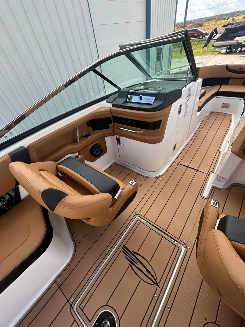 Slide: The Image of 2025 Chaparral 30 Surf boat interior with tan seating and modern dashboard. - 8