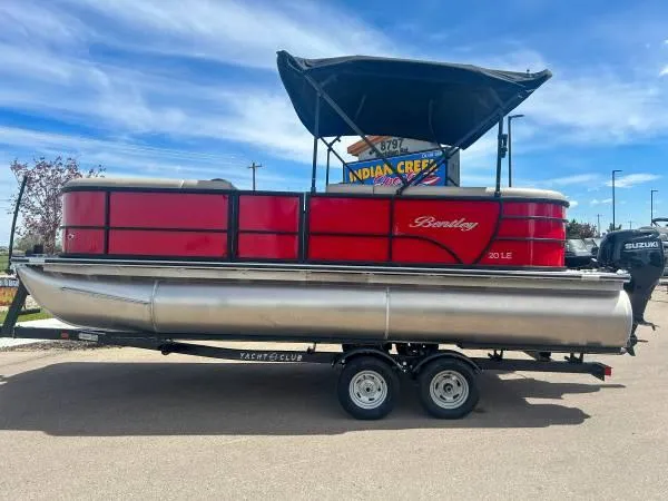 Slide: The Image of 2024 Bentley Pontoons LE 200 Cruise, red pontoon boat on trailer, outdoor display. - 2