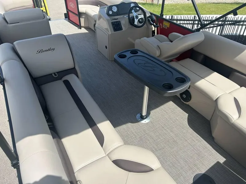 Slide: The Image of 2024 Bentley Pontoons LE 200 Cruise interior with beige seating and steering console. - 5
